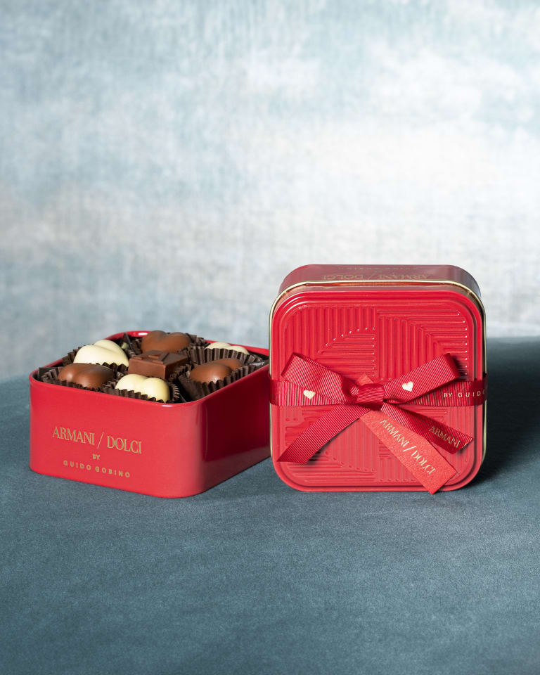 Photograph of lots of boxes of chocolates with an open box in the middle with different types of chocolates in various flavours