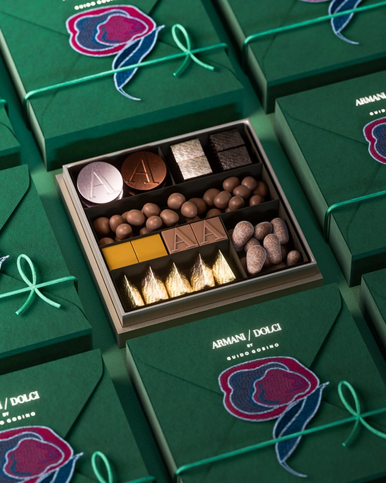 Photograph of lots of boxes of chocolates with an open box in the middle with different types of chocolates in various flavours